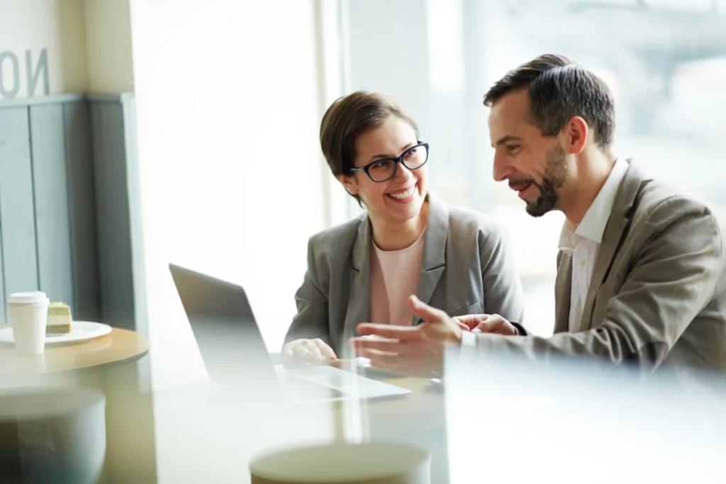 homem e mulher bem vestidos em empresa conversando atrás do computador - gestão ecommerce