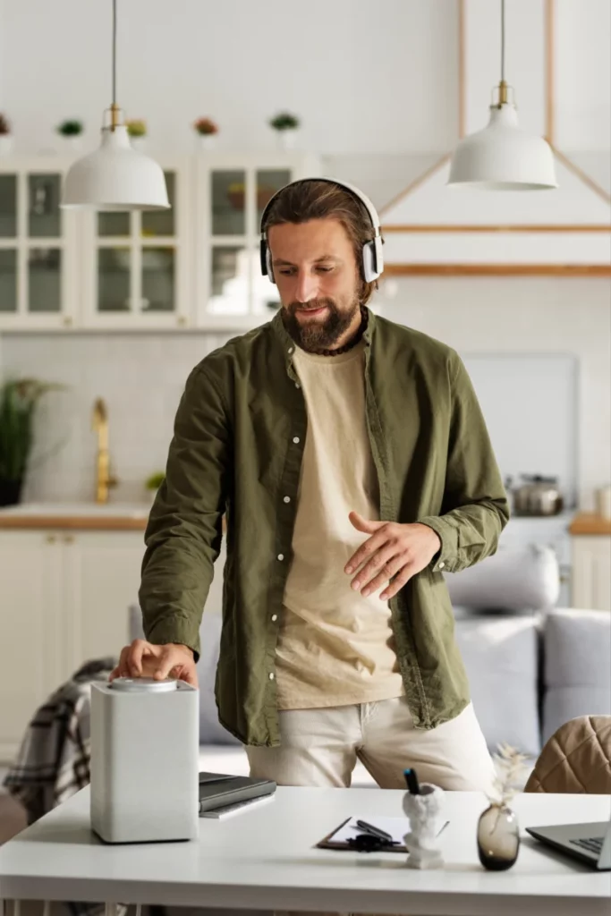 homem em casa usando fones de ouvido e outros aparelhos eletrônicos-produtos eletrônicos mais vendidos