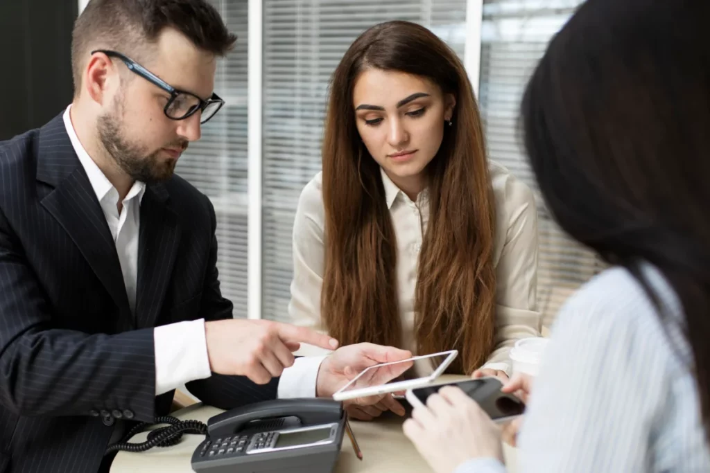 mesa com três pessoas de negócios observando seus celulares - estratégia de vendas online