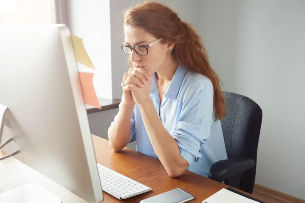 mulher pensativa em frente ao computador quero montar uma loja virtual o que vender