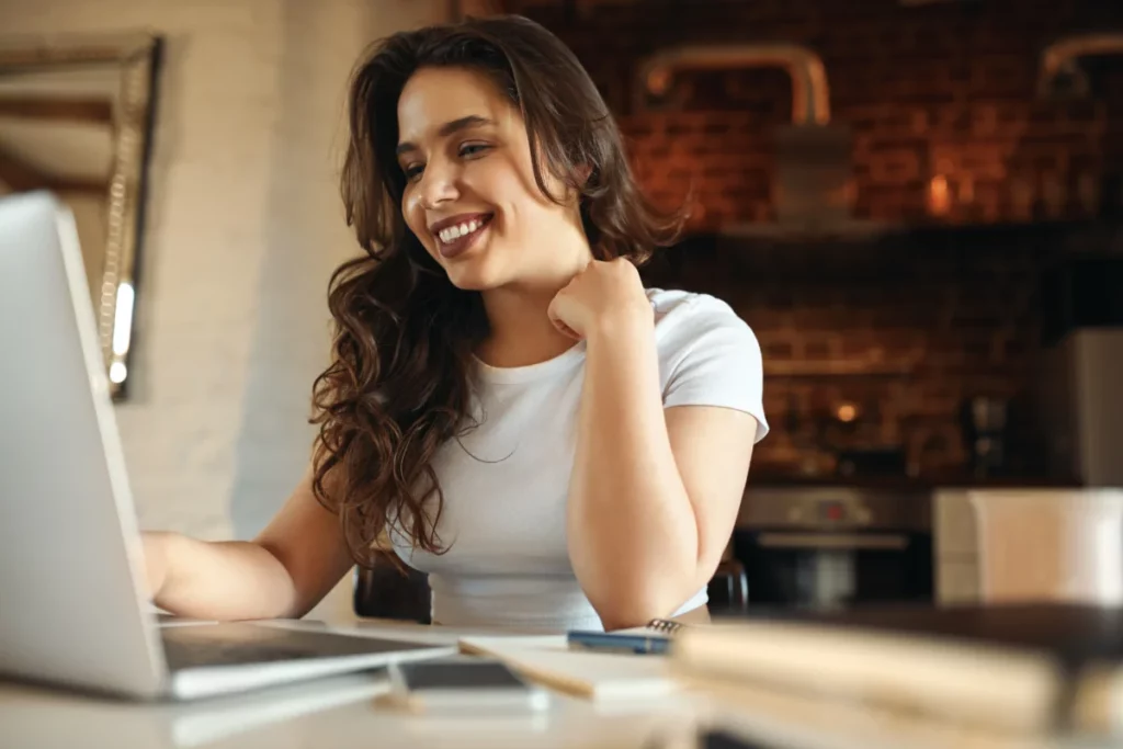 mulher sorridente mexendo no computador como aumentar as vendas online