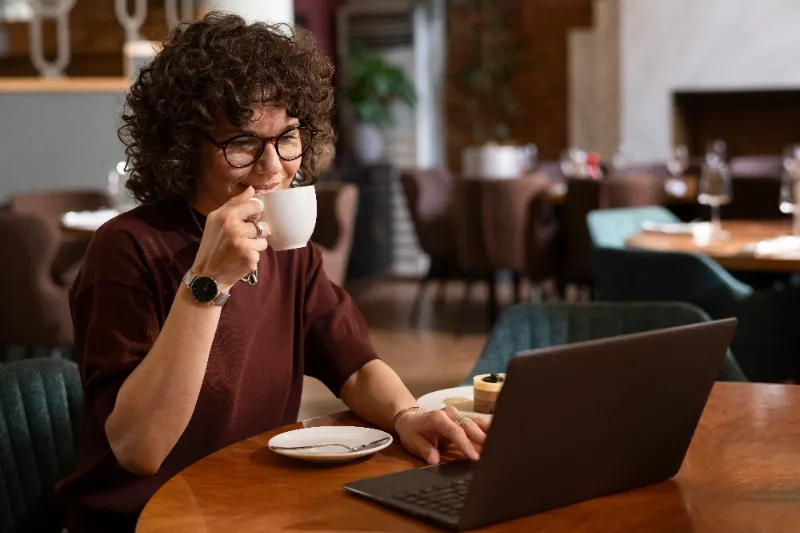 mulher tomando café enquanto trabalha de casa sentada no computador - produtos mais vendidos na shopee