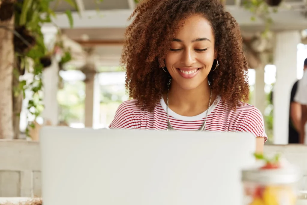 mulher negra mexendo no computador em café - o que mais vende na internet