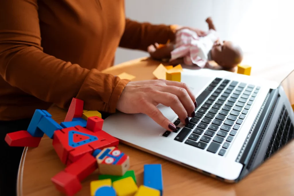 mulher trabalhando no computador com brinquedos em volta - loja de brinquedos online