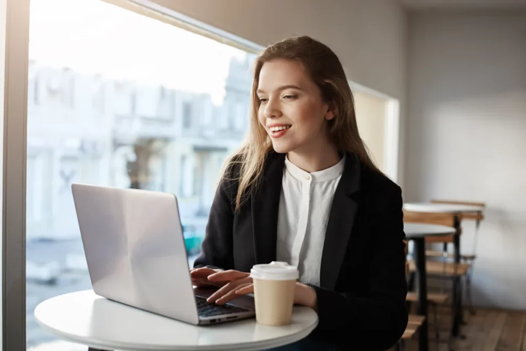 mulher trabalhando usando notebook dentro de cafeteria - nichos que mais vendem na internet