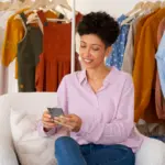 Empreendedora vendo as roupas da sua loja de roupas online exposta
