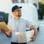 Entregador segurando uma encomenda e um envelope, representando o envio de mercadorias pelos Correios.