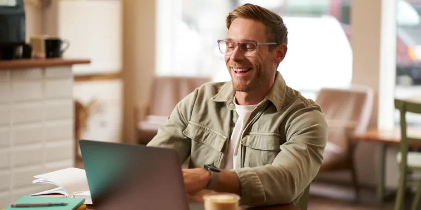 imagem-de-um-jovem-nomade-digital-de-oculos-sentado-em-um-cafe-trabalhando-em-uma-cafeteria-usando-um-laptop-nichos-mais-lucrativos