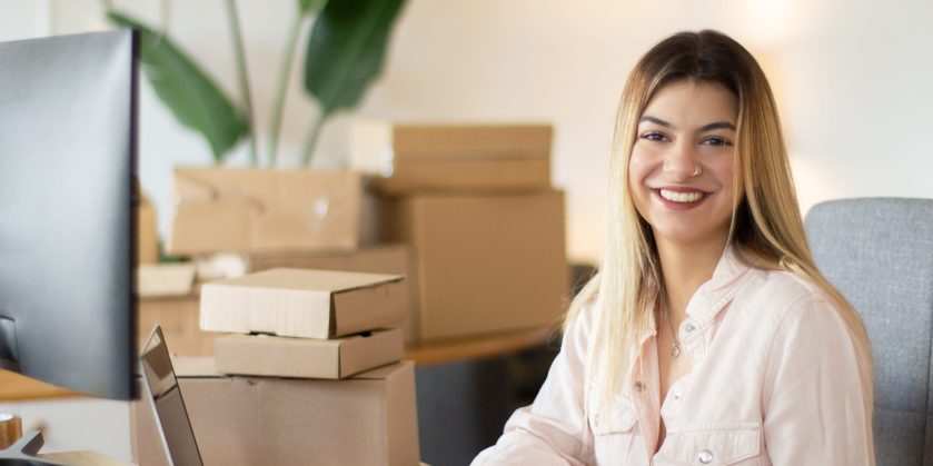 Portrait shot of happy female office worker looking at camera and smiling. Successful businesswoman working in office. Success, business, youth concept